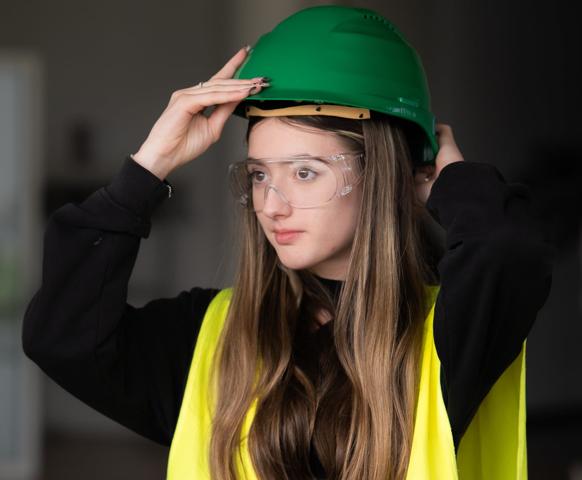 Fotografie: elevă cu cască de protecție verde și ochelari de protecție