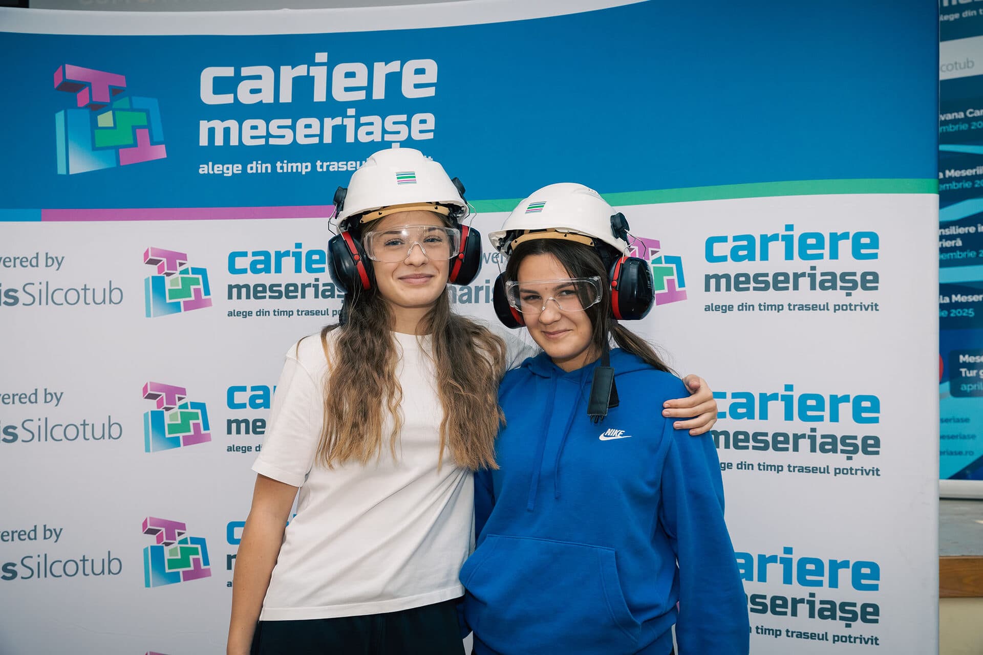 Două eleve cu cască și ochelari de protecție la un eveniment Cariere Meseriașe